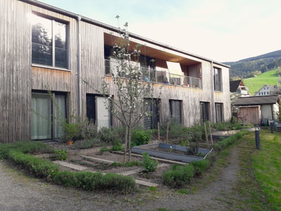 Das als Wohngruppe organisierte Good-Pratice-Beispiel in Oberried orientiert sich an einem Alltag in häuslicher Atmosphäre und liegt im Ortszentrum. Das Besondere ist, dass die Gemeinde selbst als Investor*in auftritt. Getragen wird das Projekt von der BürgerGemeinschaft Oberried, der die Verwaltung selbst übernimmt. Ein qualitativ hochwertiger Holzbau konnte realisiert werden, bei dem auf Büroräumlichkeiten verzichtet werden konnte – so kommt der gewonnene Platz den Bewohner*innen zugute. Bewohner*innen und das Angehörigengremium entscheiden selbst über das Pflegeangebot. Pflege und Betreuung sind auch für schwer pflegebedürftige Menschen bis zur höchsten Pflegestufe möglich.