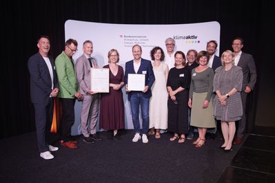Verleihung am 24. Juni 2024: Klimaschutzministerin Leonore Gewessler, Juryvorsitzender Matthias Hein, Bürgermeister der Stadt Hohenems Dieter Egger, Bernd Federspiel, Markus Schadenbauer (Schadenbauer Projekt- und Quartierentwicklungs GmbH), Jessica Schadenbauer, Judith Wellmann, Clemens Plank, Alexandra Schmid, Eva Lopez, Markus Malin, Ulrike Fenkart, Joachim Wohlgenannt