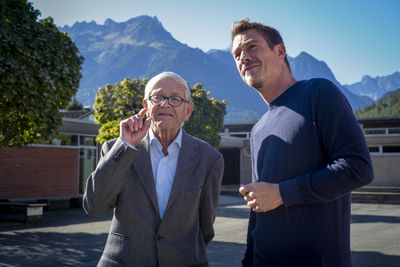 Karl Sillaber, Mitglied der Architektengemeinschaft C4, und Matthias Hein im Gespräch vor der imposanten Bergkulisse rund um die Volksschule in Nüziders, erbaut 1959–1963 von der Architektengemeinschaft C4.